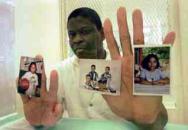 Rodney holds pictures of his children inside the visitation booth at Texas Death Row